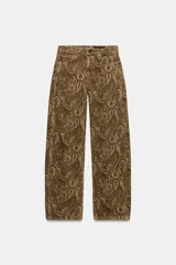 Jeans de tiro medio con diseño de perneras curvas y corte recto, confeccionados en denim con estampado paisley en tonos marrones y beige. Presentan diseño clásico de cinco bolsillos, trabillas para cinturón y cierre frontal con cremallera y botón metálico.