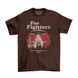 Remera marrón de manga corta y cuello redondo, con estampa frontal temática de la banda Foo Fighters, ovnis y un carpincho tomando mate.