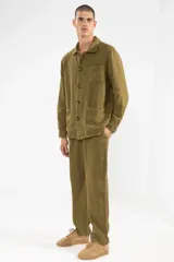 Chaqueta color verde oliva confeccionada en lino, con cuello camisero, cierre frontal con botones, manga larga con puños abotonados, un bolsillo de parche en el pecho y dos bolsillos de parche en la parte inferior.