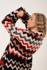 Tapado largo de lana con estampado zigzag horizontal en tonos rojo, negro, blanco y gris. De manga larga y abotonado.