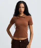 Blusa polo beige de manga corta, confeccionada en tejido canelado de rib de algodón con elastano, que proporciona un ajuste cómodo y una caída ajustada.