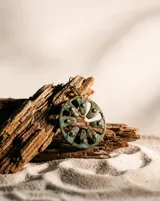 Aros colgantes de diseño circular con calados radiales y acabado en pátina de cobre oxidado, con detalles de tachas metálicas. Cuentan con pasante de plata esterlina.