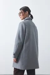Tapado corto de paño color marrón, con diseño recto, cuello camisero y cierre frontal con broches metálicos. Cuenta con bolsillos frontales.