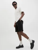 Bermuda chino de algodón color negro, con bolsillos delanteros y traseros, y cierre con cremallera.