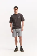 Remera boxy de algodón color beige, de silueta amplia y corta, con mangas cortas y pequeño estampado en el pecho.