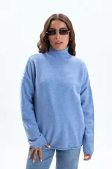Polera de tejido de punto en color celeste, con cuello alto y mangas largas de corte holgado.