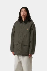 Campera de gabardina Carhartt WIP modelo Prescott, color verde militar, con cuello camisero de pana negra contrastante, cierre frontal de botones y bolsillos frontales amplios. Cuenta con detalle de logo bordado en el pecho.