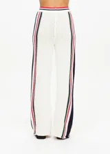 Pantalón de punto abierto de algodón orgánico color crema con rayas verticales en rojo, azul marino y verde pino. Cintura elástica acanalada con rayas de punto y silueta de pierna ancha.