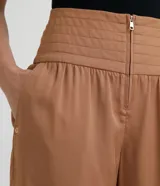 Pantalón rosado de liocel con cintura ancha y pespuntes, cierre frontal con cremallera, dos bolsillos laterales y bajo diagonal.