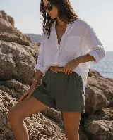 Short de lino color azul marino, de tiro alto, con bolsillos laterales y e incluye un cinto de rafia con hebilla redonda.