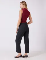 Pantalón de vestir de corte recto y tiro medio-alto, confeccionado en tela sastrera. Presenta cierre frontal con botón, presillas para cinturón y detalles de botones decorativos en carey en la cintura. Incluye bolsillos laterales funcionales y pinzas traseras para un ajuste estilizado.