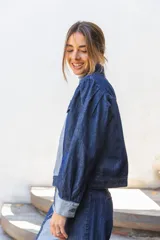 Campera clásica de jean confeccionada en denim con diseño de bloques en diferentes tonos de azul. Presenta abotonadura frontal y bolsillos delanteros.