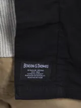 Campera tipo overshirt color azul marino, con cuello clásico, cierre frontal con botones, cuatro bolsillos frontales con solapa y puños abotonados.