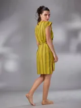 Vestido corto de lino y algodón color amarillo mostaza con diseño a rayas horizontales, escote en V y lazos para anudar en la cintura.