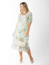 Vestido dos en uno confeccionado en seda italiana, con capa superior de calce amplio y falda con volados que aportan movimiento. Incluye forro en algodón elastizado que se adapta cómodamente a distintos talles. Un diseño versátil y liviano, ideal para eventos, días de calor o looks más relajados según cómo lo combines.