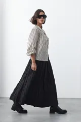 Falda larga de silueta amplia y caída fluida, con cintura elástica y textura arrugada.