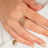 Anillo de diseño multicapa elaborado en oro de 10k, combinando bandas en oro amarillo liso y oro blanco con acabado facetado.