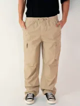 Pantalon cargo de sarga con corte loose fit, color beige, con bolsillos laterales tipo cargo y cintura elástica con cordón ajustable.