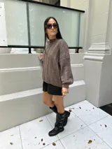 Sweater marrón tejido con diseño de ochos y cuello alto.