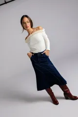 Falda midi negra de jean con corte evasé y costuras diagonales.