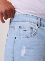 Bermuda de jean celeste con roturas y terminación desflecada.