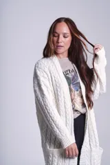 Cárdigan negro tejido con diseño de ochos, corte holgado y bolsillos frontales.