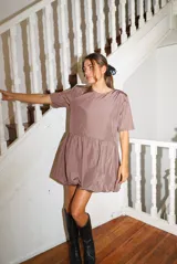 Vestido corto color verde oliva, de manga corta y corte holgado con frunce en la cintura que genera un efecto de falda globo (balloon).