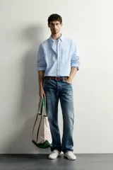 Camisa regular fit celeste confeccionada en mezcla de lino y algodón, con cuello abotonado, manga larga, bolsillo frontal en el pecho y cierre de botonadura.