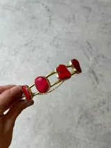 Gargantilla dorada con piedras rojas irregulares y colgante dorado con piedra roja irregular.