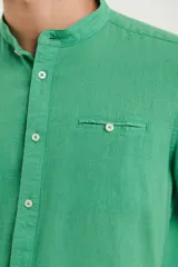 Camisa de cuello mao y manga larga, confeccionada en una mezcla de lino y algodón. Presenta un diseño de corte recto con botones en tono natural y un bolsillo pequeño en el pecho.
