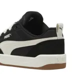 Championes Puma modelo Park Lifestyle, de diseño urbano con base negra, detalles en blanco y suela de goma color caramelo.