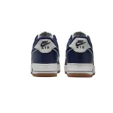 Zapatilla deportiva Nike Air Force 1 '07 LV8, caña baja, con capellada de cuero en colores azul marino y blanco. Presenta el logo Swoosh en azul marino y forro interior afelpado azul. La entresuela es de color crema y la suela exterior es de goma color caramelo.