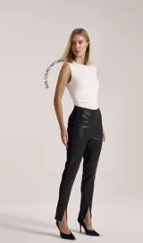 Calza de cuero negra de tiro alto con recorte en la cintura y tajos frontales en el ruedo.