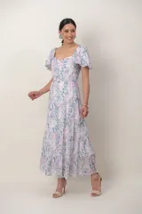 Vestido midi de gasa estampada con motivos florales en tonos pasteles, con escote corazón, mangas abullonadas cortas y falda escalonada.