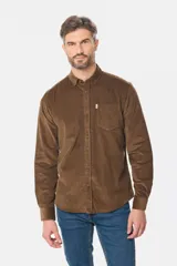 Camisa de pana fina en color verde oscuro, de manga larga con puños arremangados, cuello camisero con botones y un bolsillo aplicado en el pecho con pequeña etiqueta decorativa.