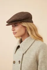 Boina con visera de lana fina uruguaya natural, sin teñir, con diseño de tejido texturizado en tonos beige y marrón.