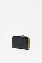 Billetera compacta Bimba y Lola de estructura rígida con textura efecto cocodrilo y acabado brillante. Cuenta con cierre de cremallera superior con tirador de tela, logo metálico dorado en el frente y compartimentos internos para tarjetas y monedas.