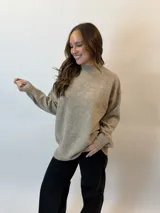 Buzo gris melange de tejido de punto, con cuello alto redondo, mangas largas y corte holgado.