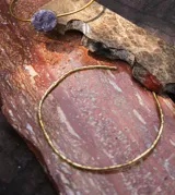 Collar rígido de bronce con diseño orgánico, textura irregular y terminación artesanal.