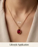 Collar de bronce con cadena fina y dije ovalado con piedra rubí sintética de corte facetado.