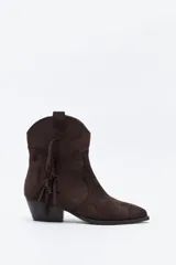 Bota texana de gamuza marrón, de caña baja, con diseño estilo western, flecos laterales decorativos y taco bajo inclinado.