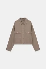 Cazadora corta color gris topo con cuello solapa, manga larga y bolsillos con solapa en el delantero. Cierre frontal con botones dorados.