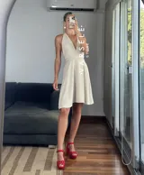 Vestido corto rojo con escote halter, espalda descubierta y falda acampanada.