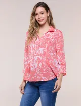 Blusa celeste con estampado efecto pincelada blanca, de corte semi holgado, escote en V con cuello solapa y media abotonadura frontal con botones nacarados. Presenta finas alforzas verticales en la pechera y mangas 3/4 con puños elastizados.
