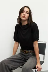 Top negro de manga corta abullonada, cuello redondo y tejido texturizado.