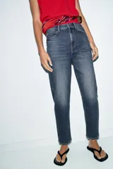 Jeans de tiro alto con corte mom fit, cinco bolsillos y cierre frontal con cremallera y botón.