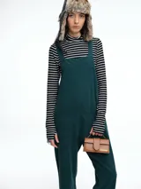 Mono largo de pana color verde oscuro, con breteles finos y silueta relajada de pierna amplia.