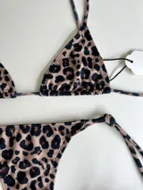 Conjunto de bikini con estampado animal print, compuesto por un corpiño triangular con tiras largas para atar en la cintura y una bombacha colaless con tiras para atar en los costados.