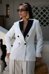 Blazer blanco con solapa de muesca en contraste color negro, doble botonadura y corte entallado.