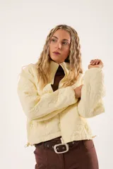 Campera color manteca con diseño acolchado de flores, cuello alto, cierre frontal con cremallera y bolsillos laterales.